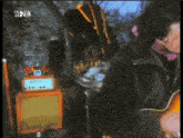 a man playing a guitar in front of an orange amplifier that says wfz08