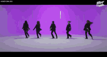 a group of women are dancing in a row on a purple background .