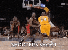 two basketball players are playing a game of basketball on a court and one of them is wearing a number 24 jersey .