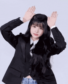 a woman in a suit and tie is making a gesture with her hands