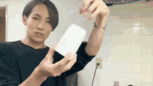 a man in a black shirt is holding a piece of white paper