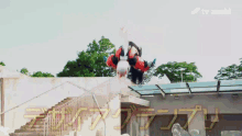 a person is upside down in the air with a tv asahi logo above them