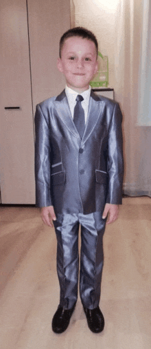 a young boy wearing a grey suit and tie