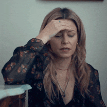 a woman with a ring on her finger is holding her head
