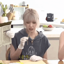 a woman wearing gloves is sitting at a table eating food