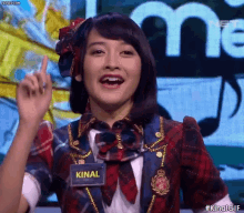 a girl wearing a name tag that says kinal on it