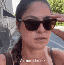 a woman wearing sunglasses says vcs me odeiam on the bottom
