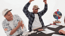 a man wearing a hat that says flicker is sitting at a table with other people