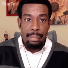 a man with a beard is wearing ear buds and looking at the camera with the words star talk behind him