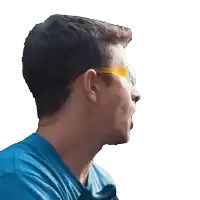 a man wearing a blue shirt and yellow glasses looks to his left