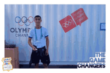 a man stands in front of a sign that says olympic chann