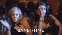 a couple of women standing next to each other in a club with the words `` janet-time '' written on the bottom .