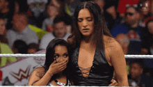 two women in a wrestling ring with the word win on the bottom right