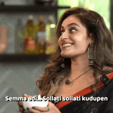 a woman is smiling and holding a cup of coffee with the words semma adi sollati sollati kudupen below her