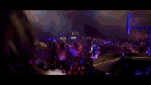 a blurry picture of a person 's hands reaching out towards a purple light