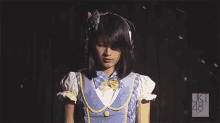 a girl in a blue and yellow outfit with the number 48 on the bottom right