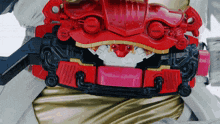 a close up of a red and black toy with a pink button that says ' a ' on it