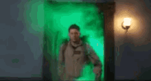 two men are standing next to each other in a room with a green light on the wall .