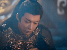 a close up of a man wearing armor and a crown on his head .