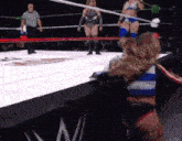 two women are wrestling in a ring with a referee