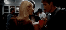 a man and a woman are standing next to each other at a party .