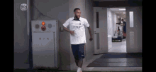 a soccer player wearing a qatar shirt is running in a hallway
