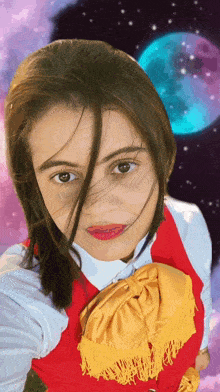 a girl wearing a red vest with a yellow fringe is taking a selfie