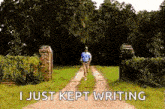 a man is running down a dirt road with the words `` i just kept writing '' written on the ground .