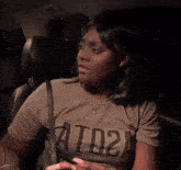 a woman sitting in a car wearing a t-shirt that says ato2