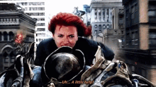 a woman with red hair is riding a motorcycle and saying a little help