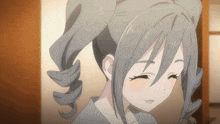 a close up of a girl 's face with her eyes closed and her hair in pigtails