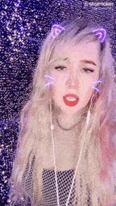 a girl wearing headphones and a cat ear headband looks at the camera