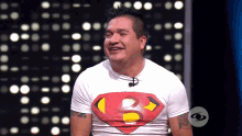 a man wearing a superman shirt with the letter b on the chest