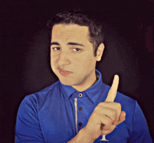a man wearing a blue shirt with the letter i on the front