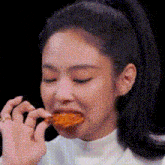 a woman is eating a piece of food with her mouth open .