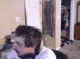 a man wearing headphones is sitting in front of a closet
