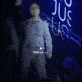 a man in a denim jacket is singing into a microphone in front of a sign that says state