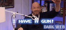 a man in front of a microphone with the words i have a gun dark web