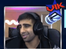 a man wearing headphones is smiling in front of a blue star that says uk