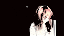 a girl with pink hair is wearing a white shirt and a white hat