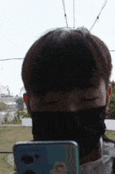 a man wearing a face mask is looking at his phone