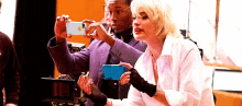 a man and a woman are taking a selfie with their phones .