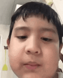 a young boy is making a funny face with his eyes closed and his mouth open .