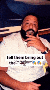 a man with a beard wearing a white shirt with the words tell them bring out the on the bottom