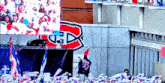 a crowd of people watching a hockey game with a banner that says canadiens on it