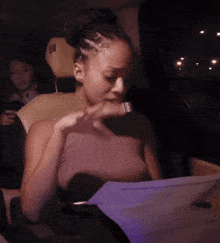 a woman is sitting in the back seat of a car looking at something
