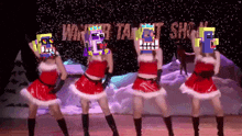 a group of women in santa costumes are dancing in front of a sign that says winter talent show