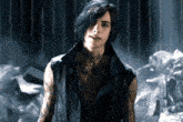 a man with a tattoo on his chest is standing in a dark room
