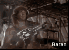 a man holding a gun with the word baran on the bottom right