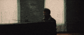 a man playing a piano in front of a painting